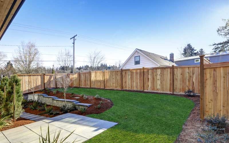 Sloped backyard surrounded by wooden fence Luxury New constructi