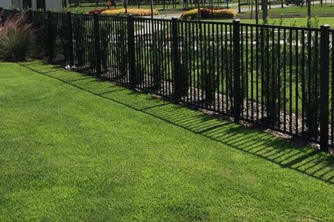 an aluminum fence in a grassy yard