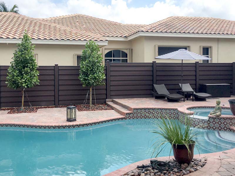 a trex fence surrounding a pool in front of a Florida home
