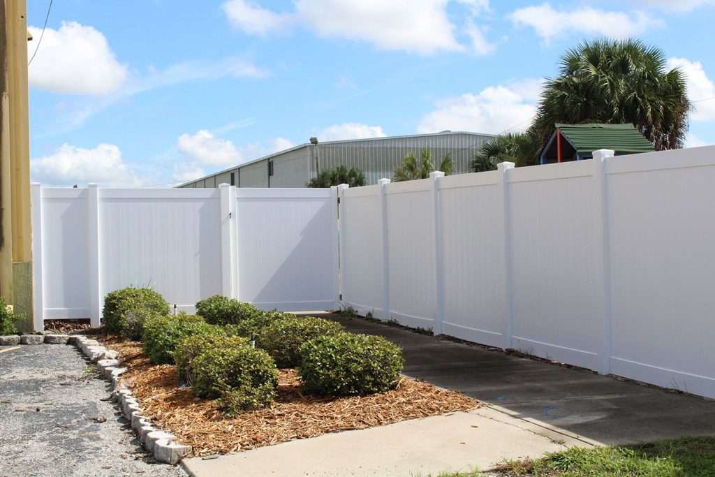 a white vinyl fence with gate