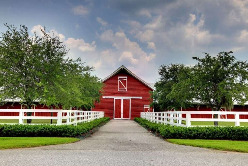 a vinyl fence with a barn