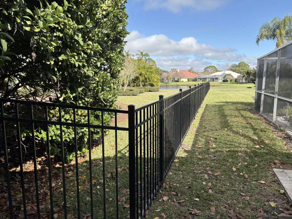 An flat top aluminum fence in a backyard